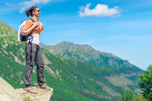 horizontal portrait of a happy tourist with a backpack on a background of high mountains