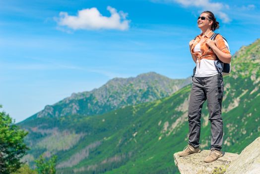 tourist with a backpack in a mountain hike against the background of beautiful high mountains