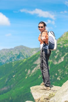 tourist with a backpack stretches his hand, shooting in the mountains