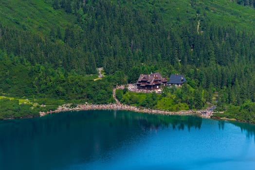 shore of Lake Morskie Oko in the Tatras, tourists on the bank in a sunny day