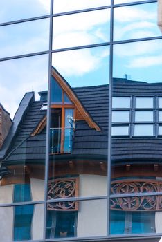 mirror wall of a building with a reflection of a wooden house