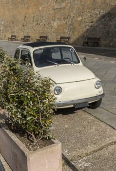 nice old white car parked in the streets of alghereo on the italian island of sardinia