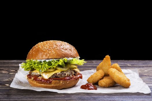 Craft beef burger and french fries on wooden table