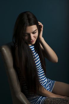 Young attractive woman on dark blue wall background