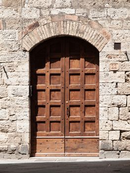 Old brown wooden door in medieval street.