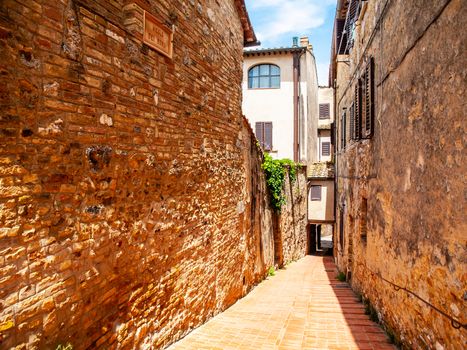 Picturesque medieval narrow street of San Gimignano old town, Tuscany, Italy.