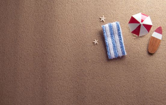 Miniature parasol and towel on beach sand