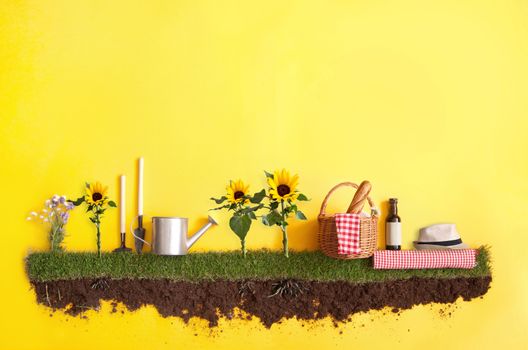 Summer picnic basket on grass patch with sunflowers