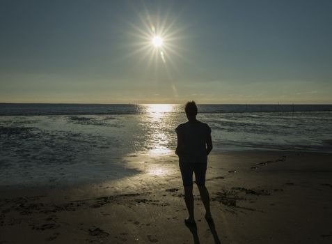 Rockanje,Holland,13-07-2018:Woman standing at the bach during sunset looking at the sea in Rockanje,Rockanje is a famous beach spot in Holland