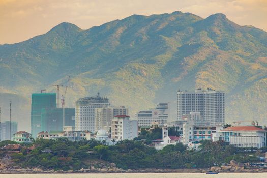 Nha Trang, Vietnam, Asia July 3 2018. Vietnamese holiday resort beach front skyline scene with skyscraper hotels and apartment blocks. With the rugged mountain landscape in the background.