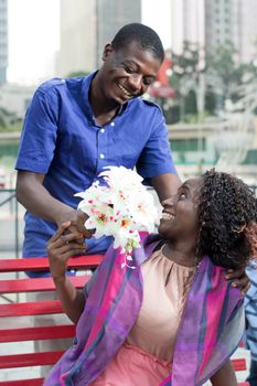 man made a surprise to his beloved by offering her flowers.