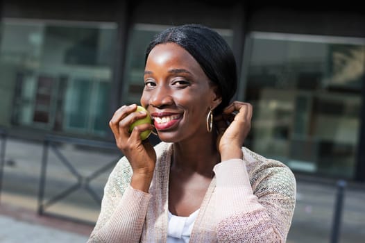 This young woman with a beautiful smile, stick an apple on her check.
