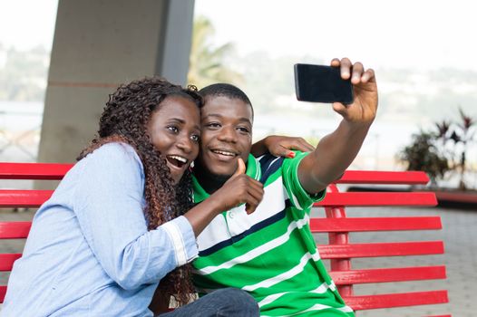 young couple takes pictures to mark their ride in the public square.