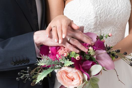 Beautiful wedding bouquet in bride's and groom's hands close up view