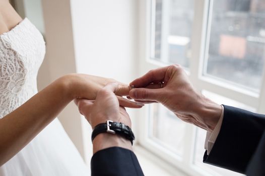 Groom places the wedding ring on the bride's finger