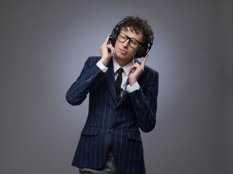 Funny man in headphones listening music, studio shot on gray background