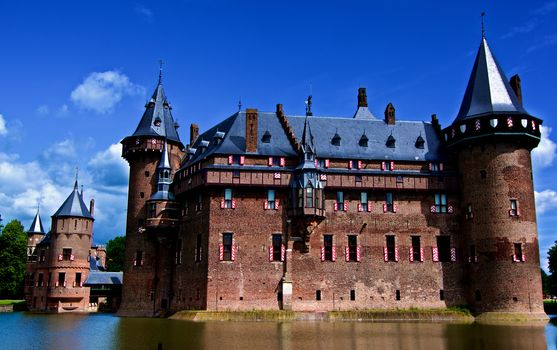 Medieval Castle De Haar from side of Moat against Blue Sky Outdoors. Utrecht, Netherlands