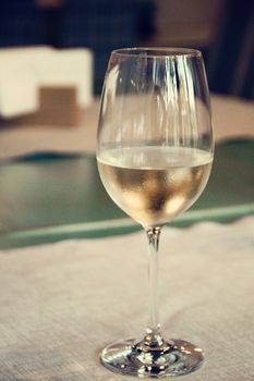 one wineglass with white wine on the table. photo