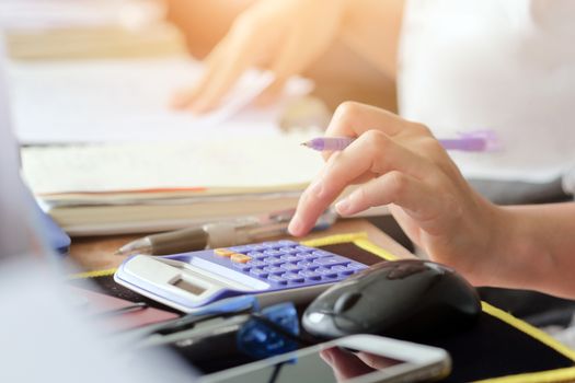 close up female hands of accountant with calculator and pen. business accounting background.