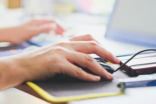 Close-up of female hands using laptop computer, working on laptop with flare light background. Searching Internet ,Businesswoman working at home office