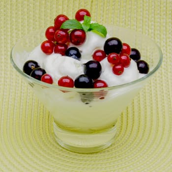 Glass vase with ice cream decorated with black and red currant