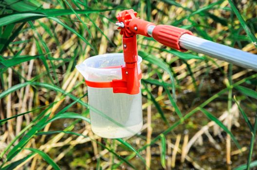 Take samples of water for laboratory testing. The concept - analysis of water purity, environment, ecology