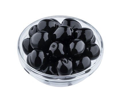 Heap of black olives in glass bowl isolated on white background with clipping path, close up