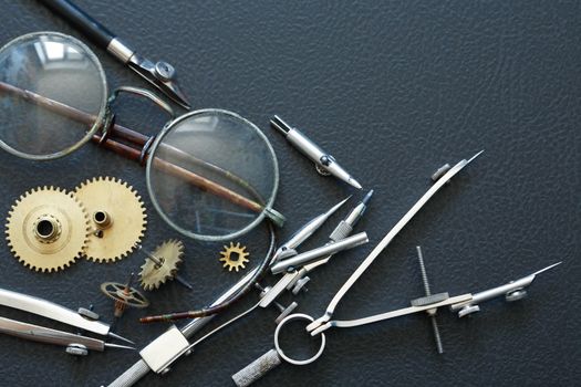 Engineering concept. Set of gears near divider and old spectacles