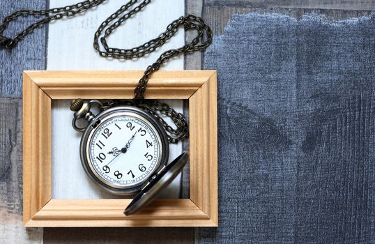 Vintage still life with old pocket watch inside wooden picture frame