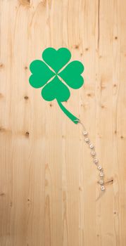 The german words for Good Luck and a cloverleaf on a cord on wood