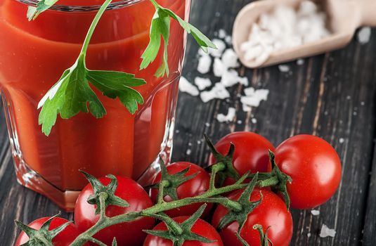 Closeup of tomato juice and cherry tomatoes. Blurred background.