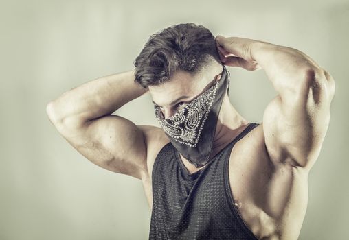 Handsome muscular young man with mask over face as a robber or bandit