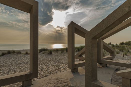 wooden structure on the beach with the clouds and sunset in the background, this is europoort maasvlakte beach in the evening