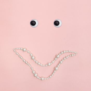 Shiny pearl smile and eyes, on pastel pink background.