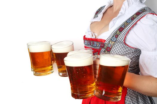 Young sexy woman wearing a dirndl with beer mugs isolated on white background, Oktoberfest concept