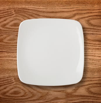 Empty white plate on wooden table