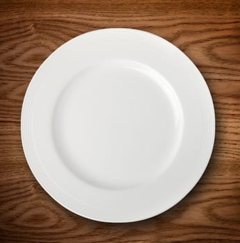 Empty white plate on wooden table