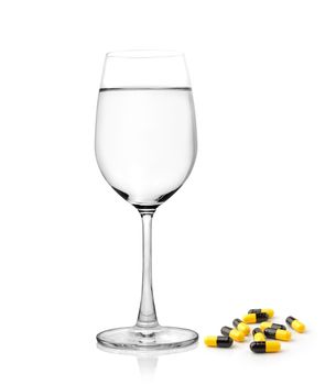 glass of water and pills capsules isolated on white background