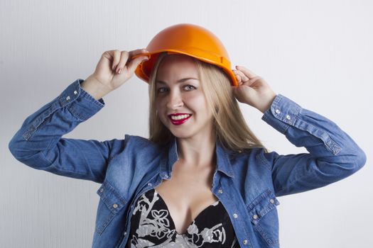 Young beautiful blonde woman in a construction helmet