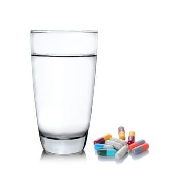 Glass of water and pills isolated on white background