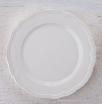 Empty white plate on wooden table