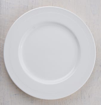 Empty white plate on wooden table