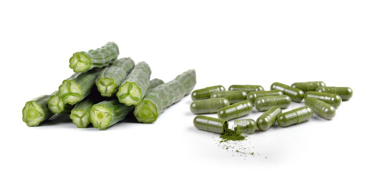 Moringa capsule pills on white background