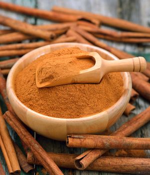 Cinnamon sticks and powder cinnamon in the bowl on table