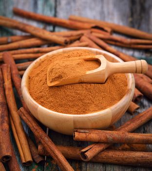 Cinnamon sticks and powder cinnamon in the bowl on table