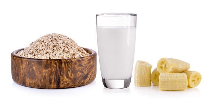 Oat flakes, banana and milk on white background