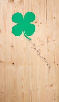 The german words for Good Luck and a cloverleaf on a cord on wood