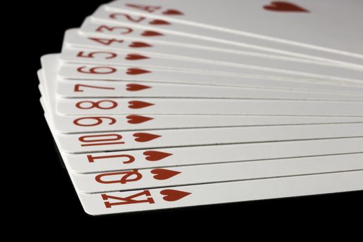 Hearts Playing Cards Spread Out on black background.