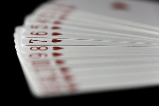 Hearts Playing Cards Spread Out on black background.