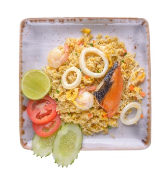 Fried rice with squid, salmon, shrimp in ceramic plate  isolated on white background